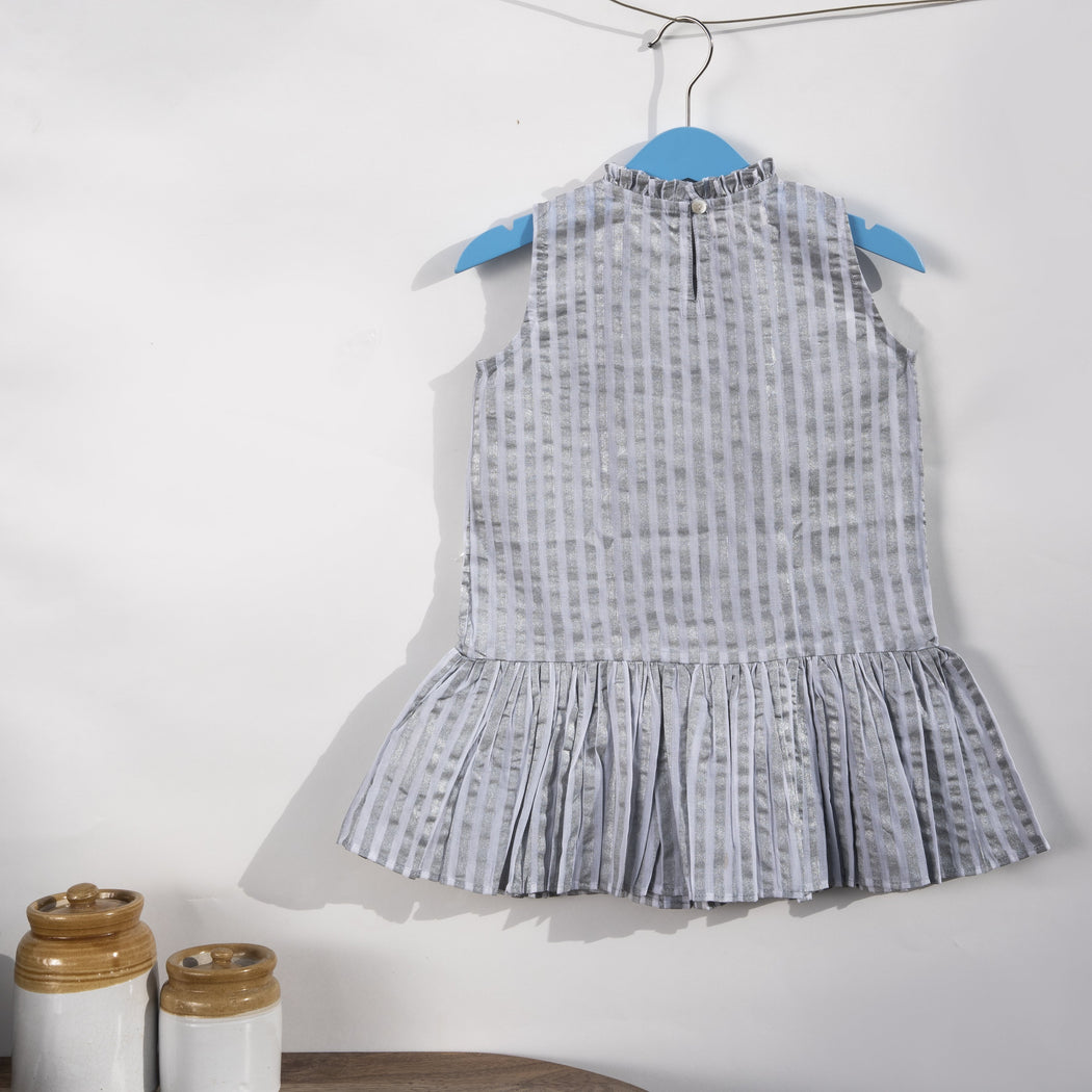A white cotton mulmul shift dress for kids, hand-block printed with silver stripes..Dress has back button fastenings.